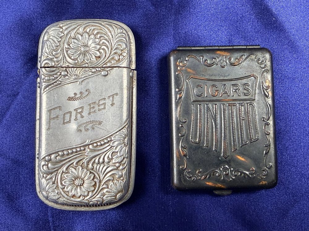 Lot 66: Two Vintage Match Safes Including an Engraved 1924 Repousse Case and a United Cigars Advertising