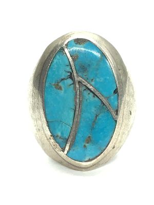 Artisan made ring. Sterling silver ring featuring turquoise inlay. 18.16 grams of total weight. 