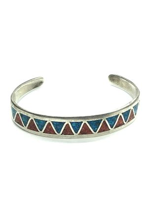 Artisan made cuff bracelet. Sterling silver cuff featuring crushed turquoise and red coral. 