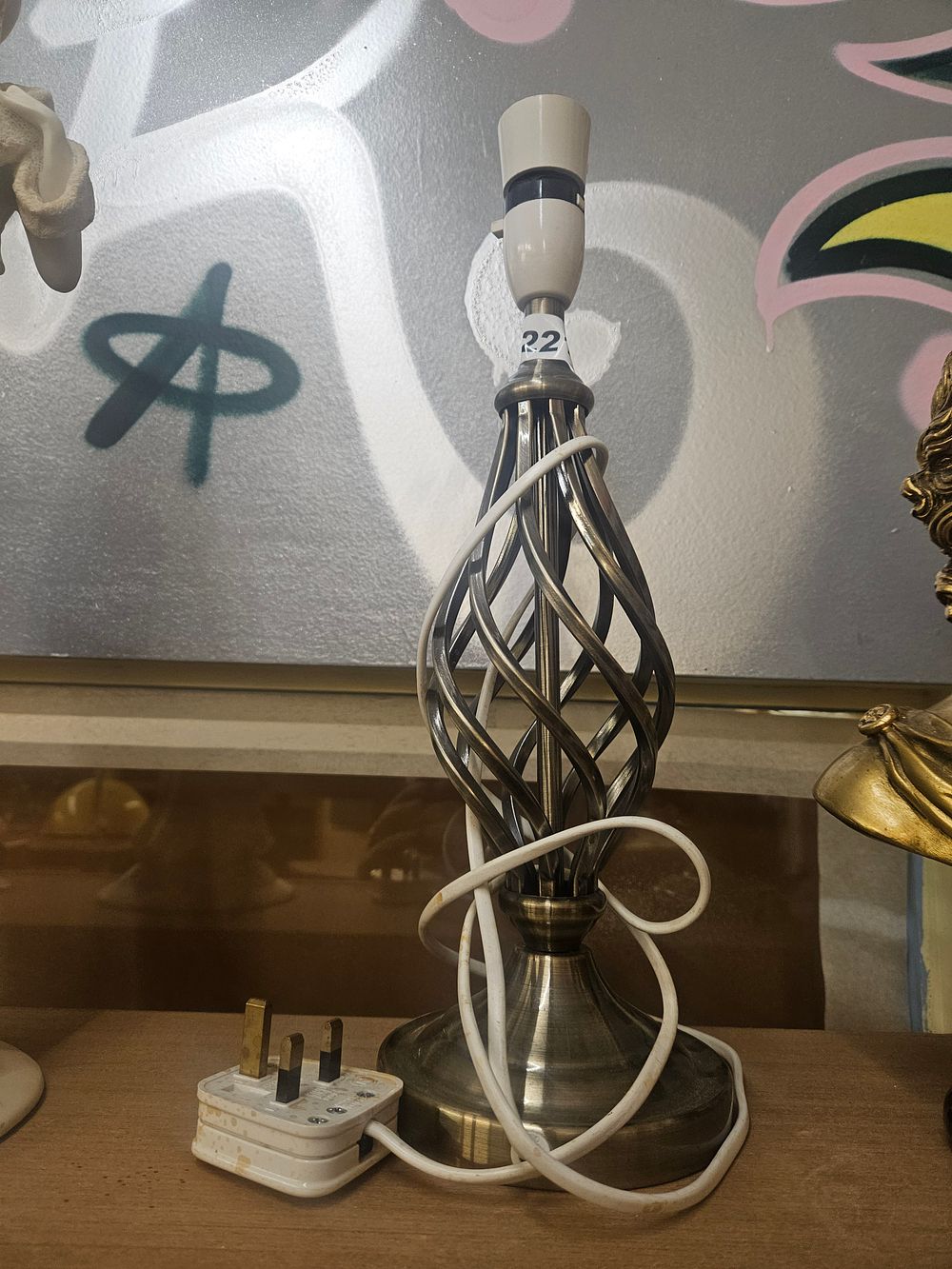 Lot 221 – A contemporary antiqued brass effect metal table lamp with twisted cage stem