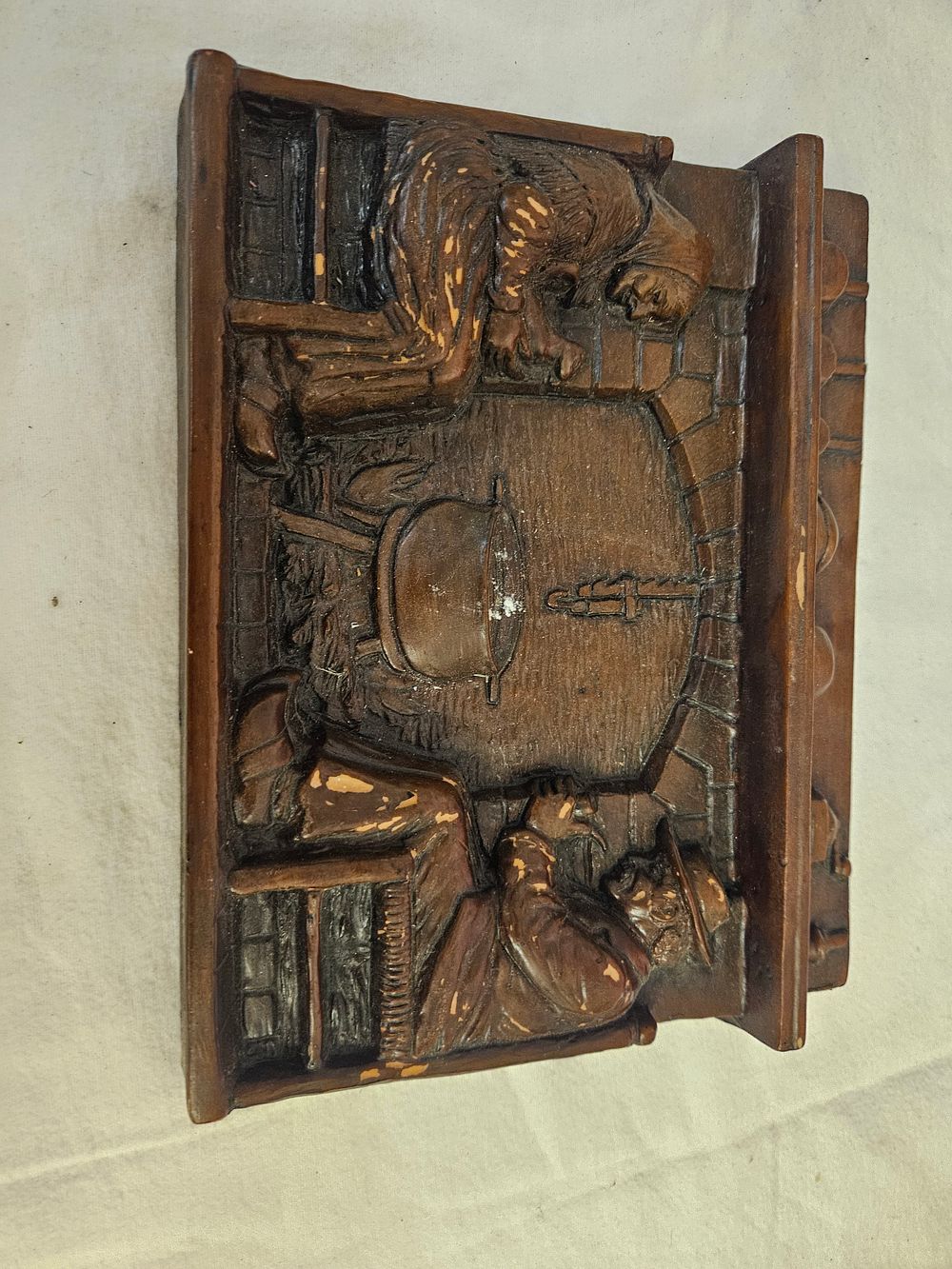 Lot 236 – A Moulded Faux-Wood High-Relief Plaque Depicting a Cottage Interior Scene
