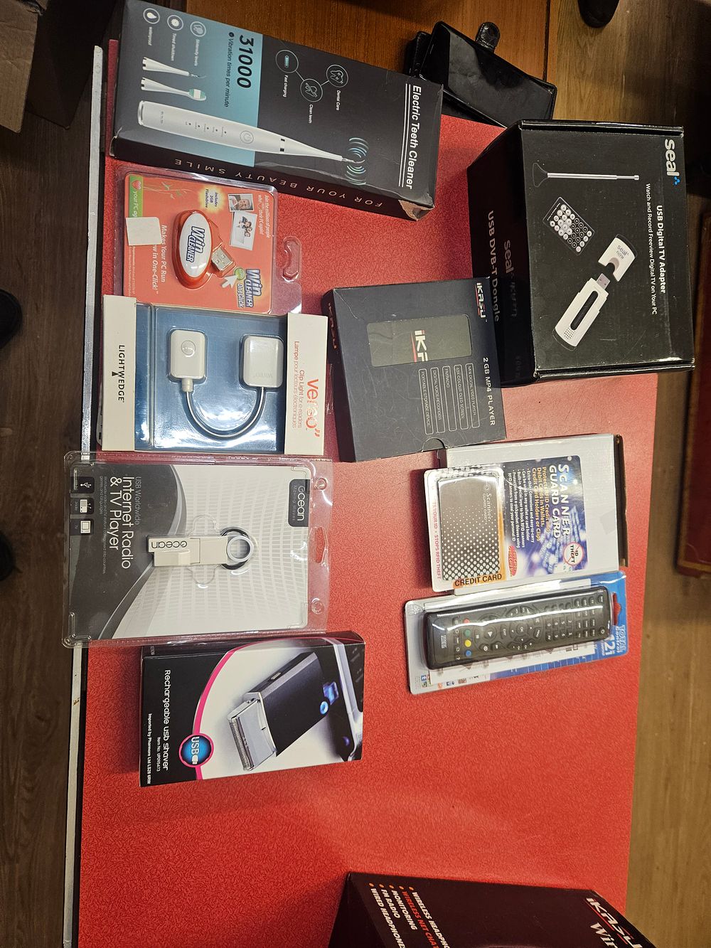 Lot 261 – An Assortment of Branded Small Electronics and Personal Care Gadgets Including USB Adapters, Media Players, and Grooming Tools