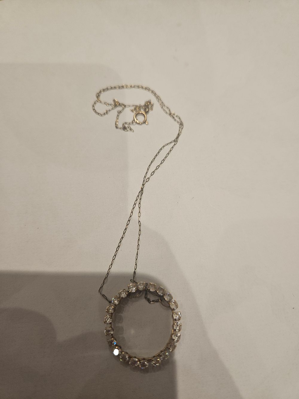Lot 436 – A 9ct white gold circular pendant necklace set with colourless stones 2.2grams