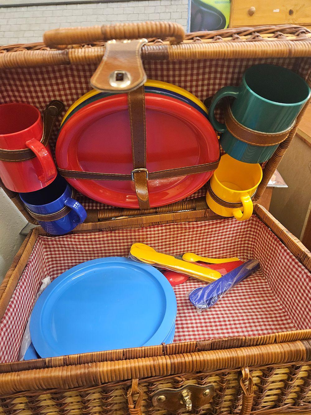Lot 217 – A Wicker Picnic Hamper with an Assortment of Colourful Plastic Tableware