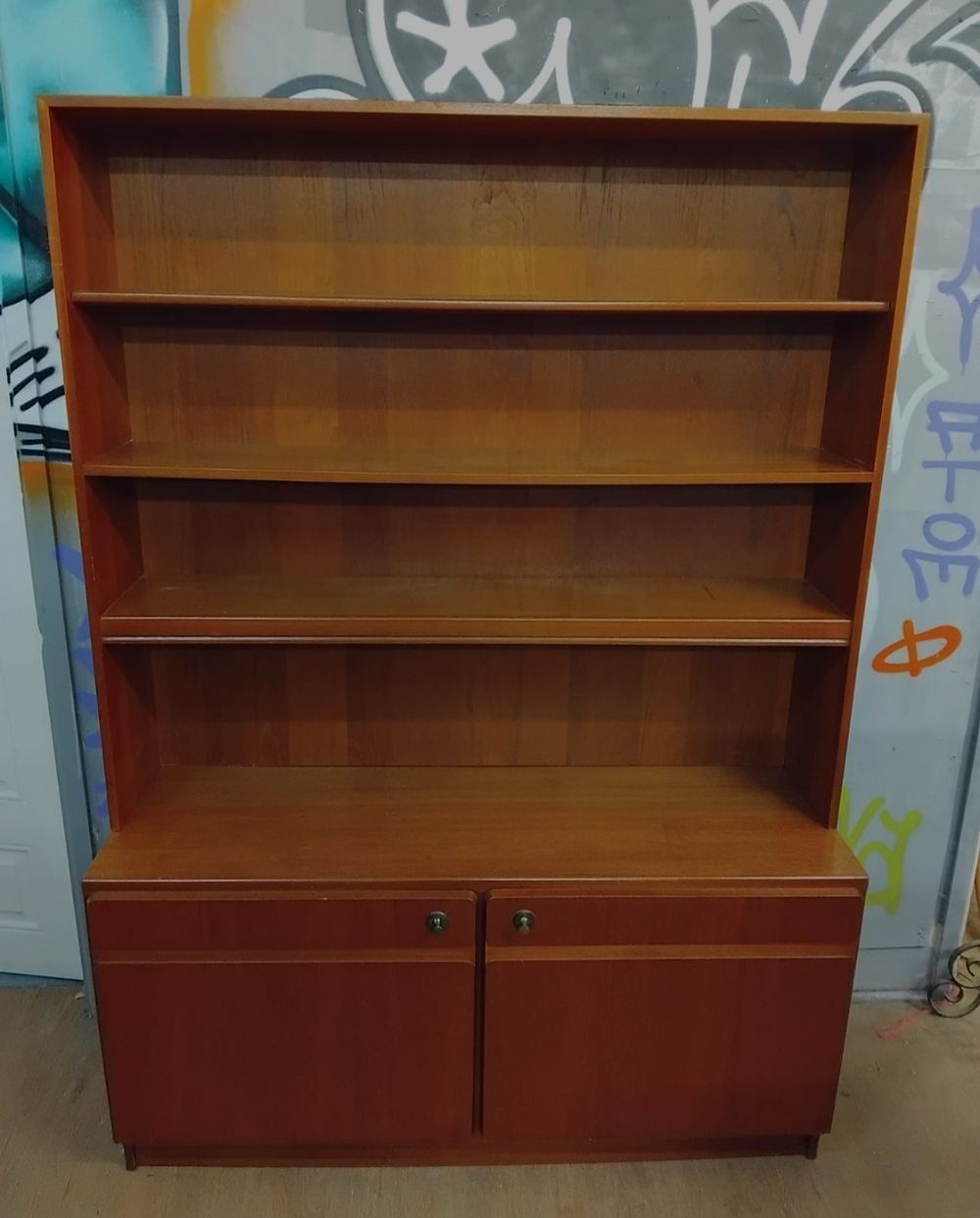 Lot 309 – Mid-century modern teak-veneered two-part bookcase and cupboard unit