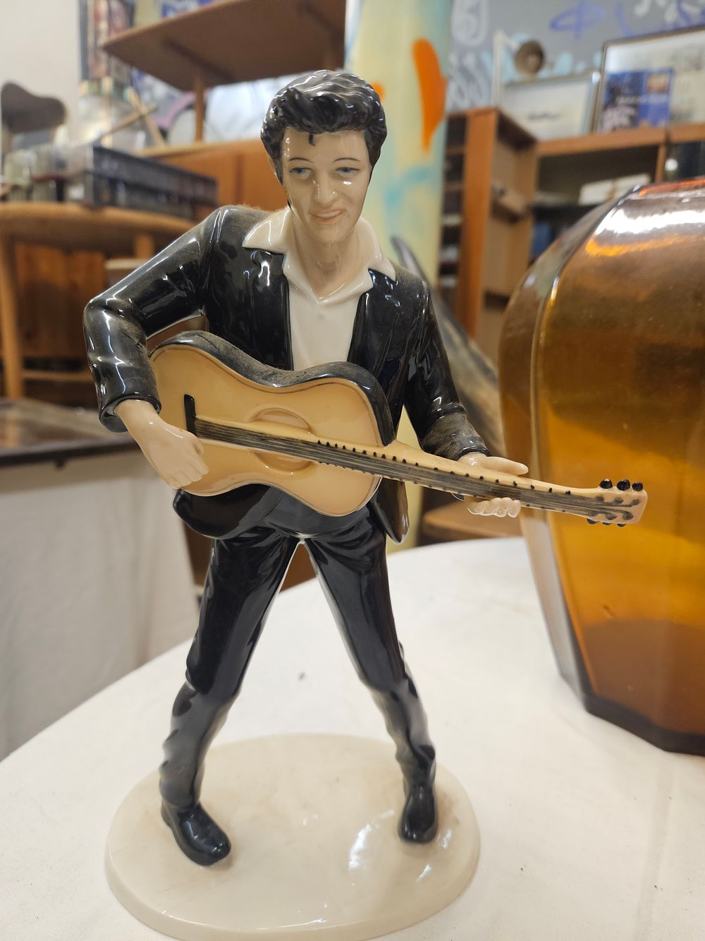 Lot 151 – A glazed porcelain figurine of Elvis Presley with a guitar