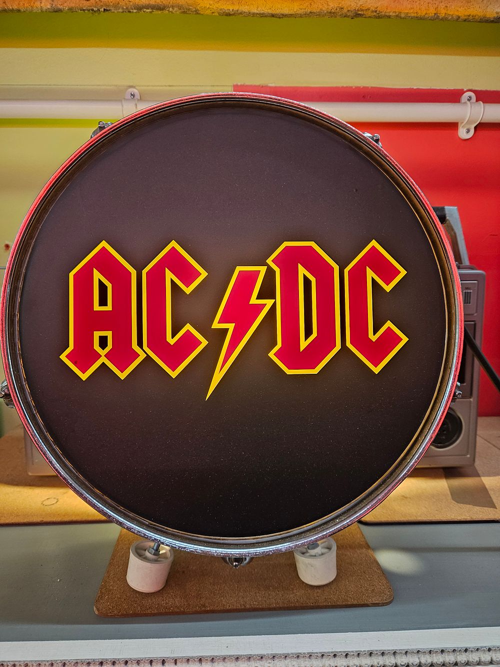Lot 184 – A decorative single-headed tom-tom drum featuring the AC/DC logo