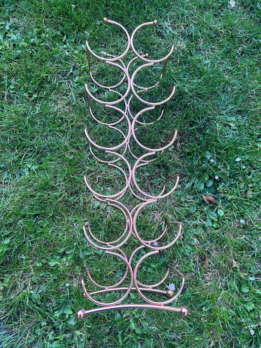 Lot 278 – A Contemporary Rose Gold Toned Metal Freestanding Eighteen Bottle Wine Rack