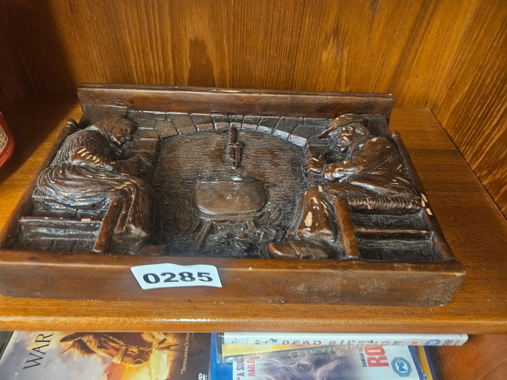Lot 285 – A rectangular relief plaque depicting a rustic hearth scene