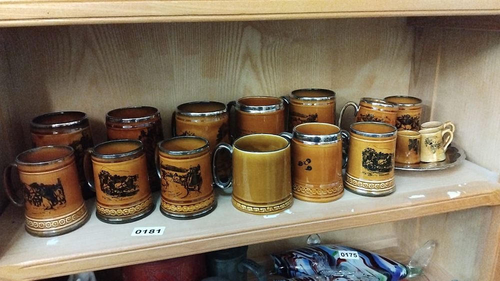 Lot 181 – A Collection of Fourteen English Earthenware Coaching Scene Tankards and Miniature Mugs