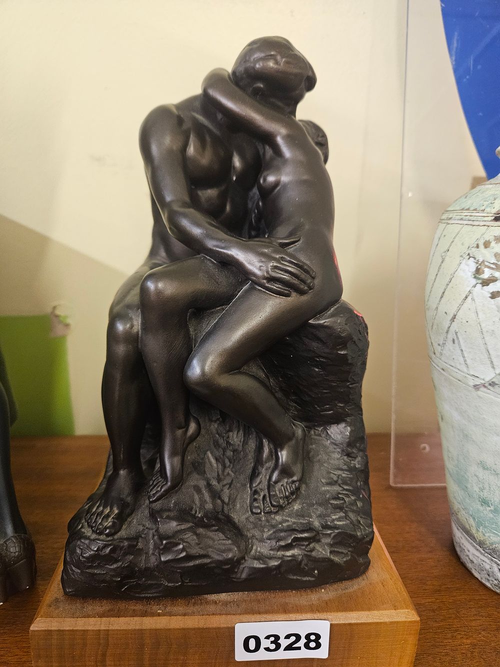 Lot 328 – A dark-patinated sculpture after Auguste Rodin’s The Kiss, on a wooden plinth