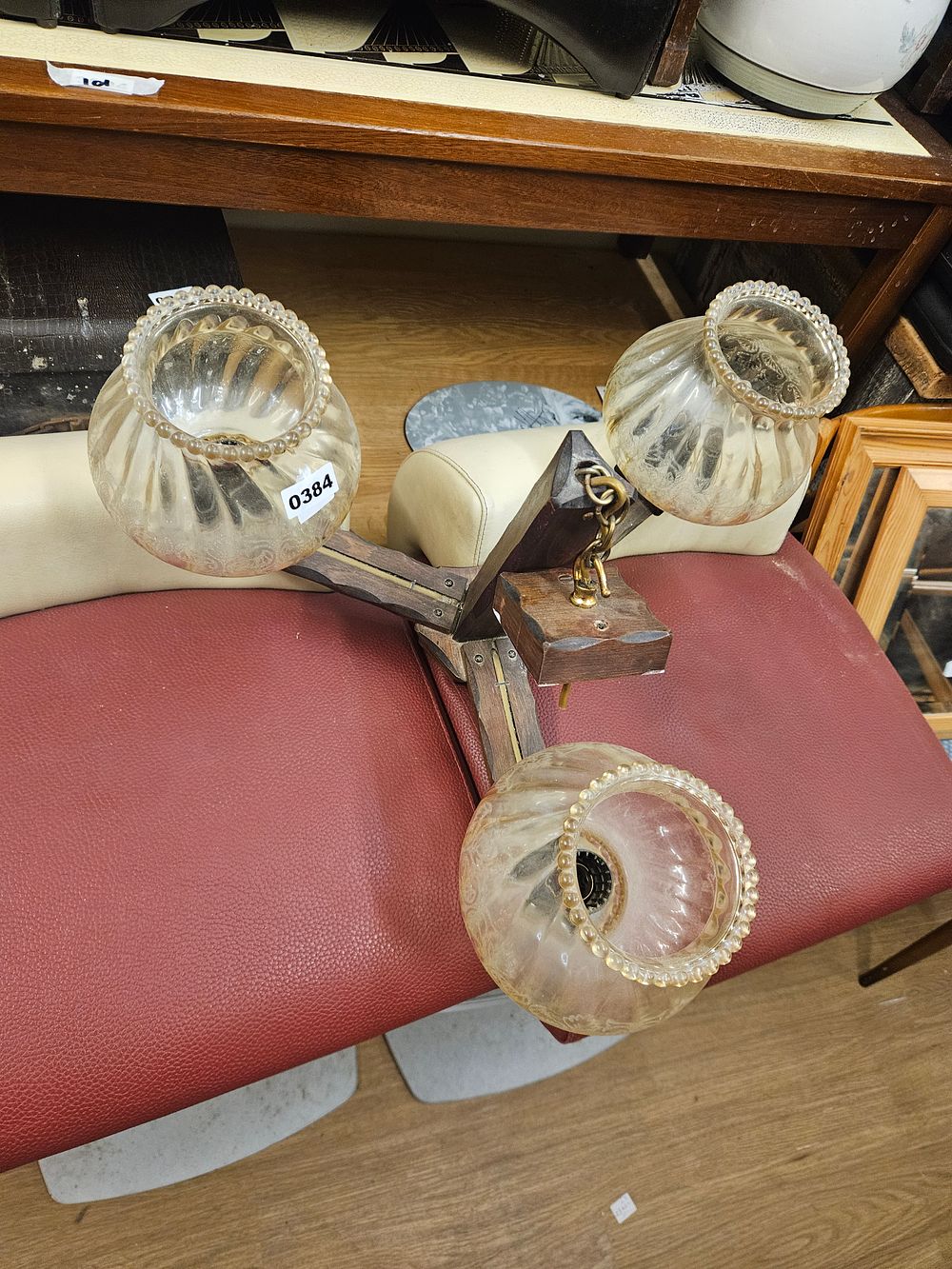 Lot 384 – A mid-20th century three-arm wooden ceiling light with fluted amber glass shades