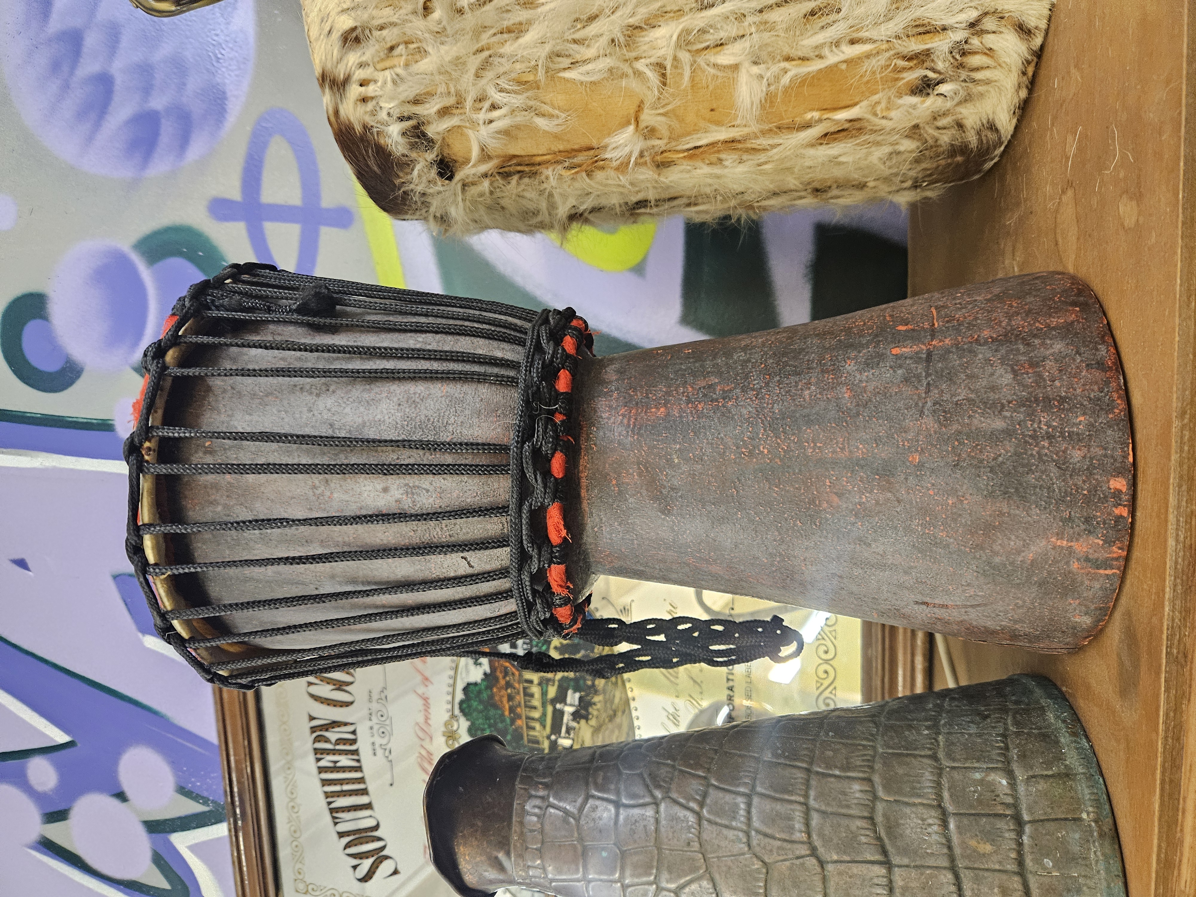 A Trio of Ethnic Style Decorative Objects Including a Carved Wood Djembe Drum