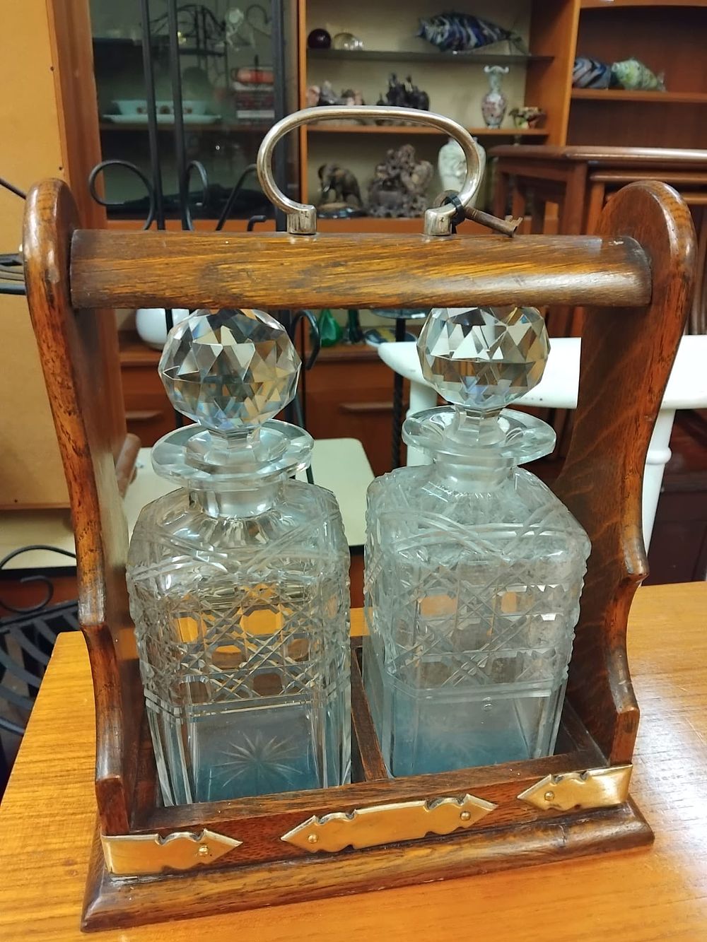 Lot 172 – An Edwardian Oak and Brass Two-Bottle Tantalus with a Pair of Cut Glass Decanters