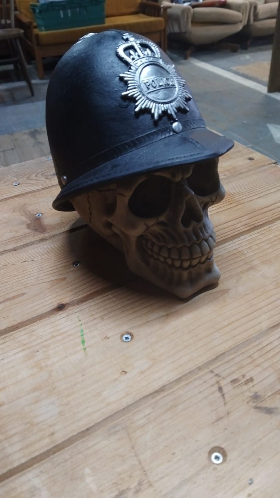 Lot 301 – A Decorative Resin Sculpture of a Skull in a British Police Custodian Helmet