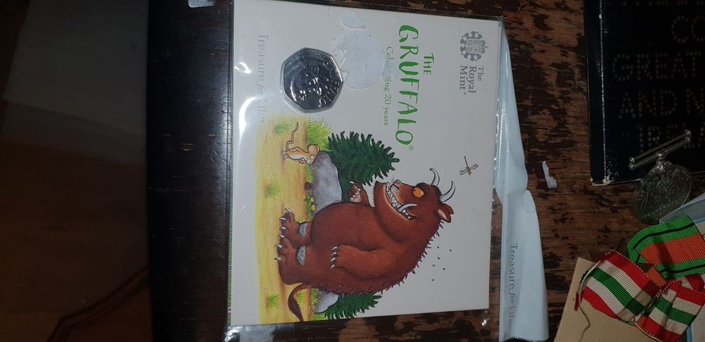 Lot 454 – Two Items comprising a 2019 UK The Gruffalo 50p Coin Pack and a Military Medal
