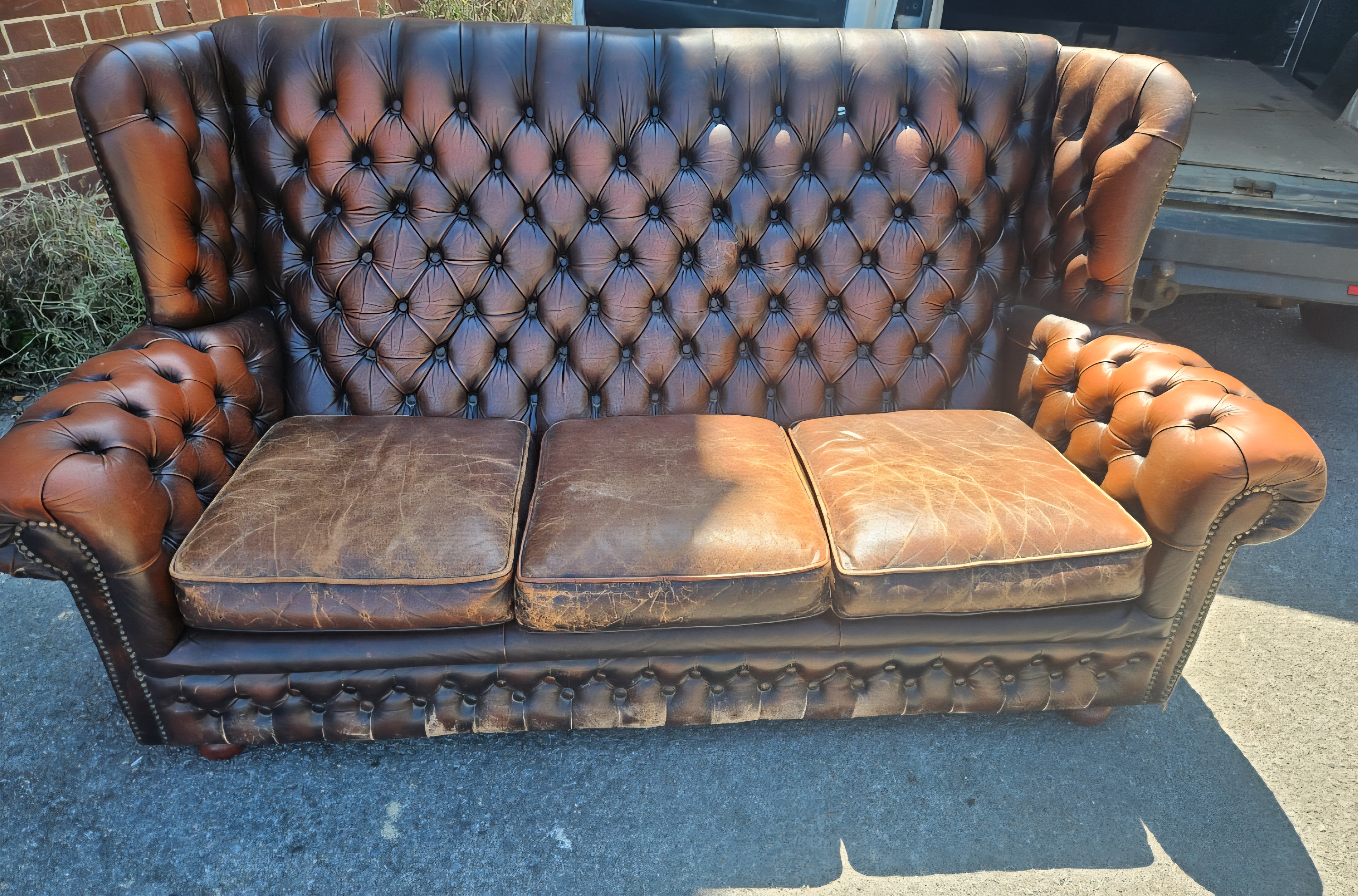 A Thomas Lloyd Three Seater Wingback Chesterfield Sofa in Brown Leather