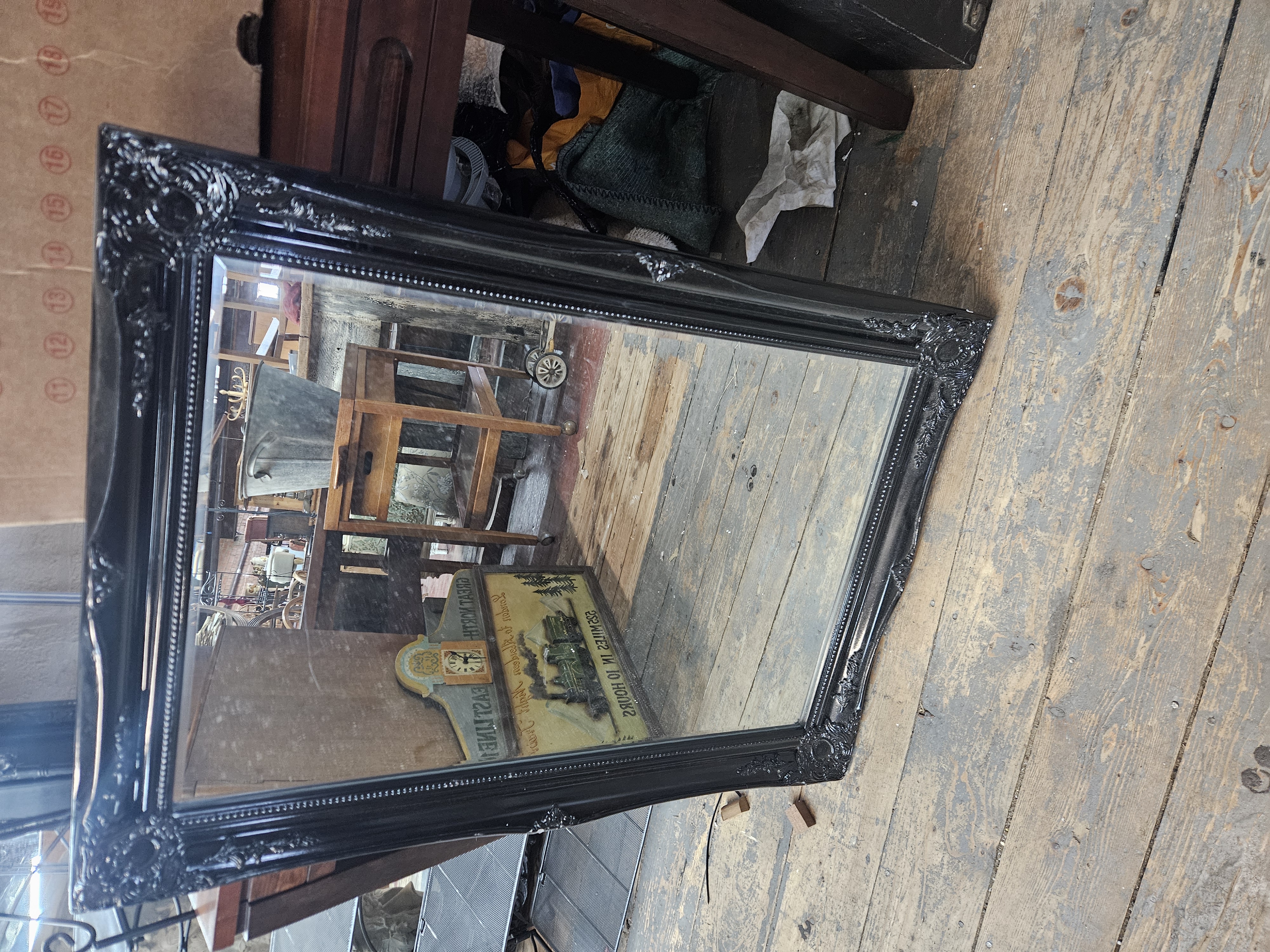 An Ornate Black Swept Wall Mirror