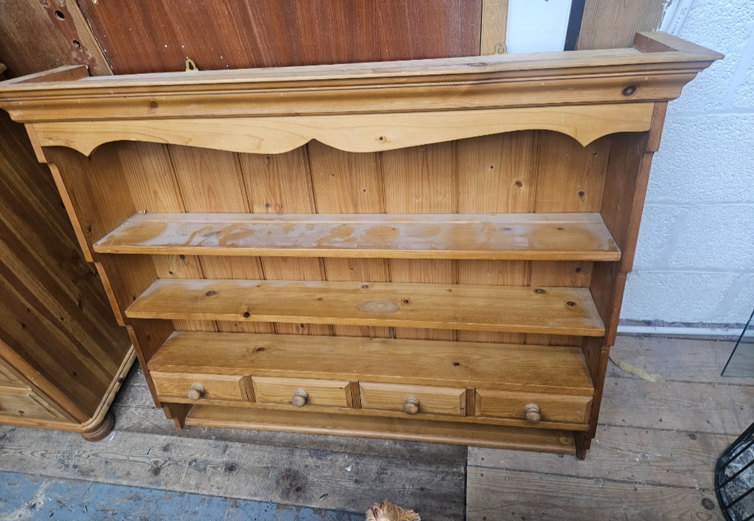 A late 20th-century pine wall-mounted open shelf unit with four drawers