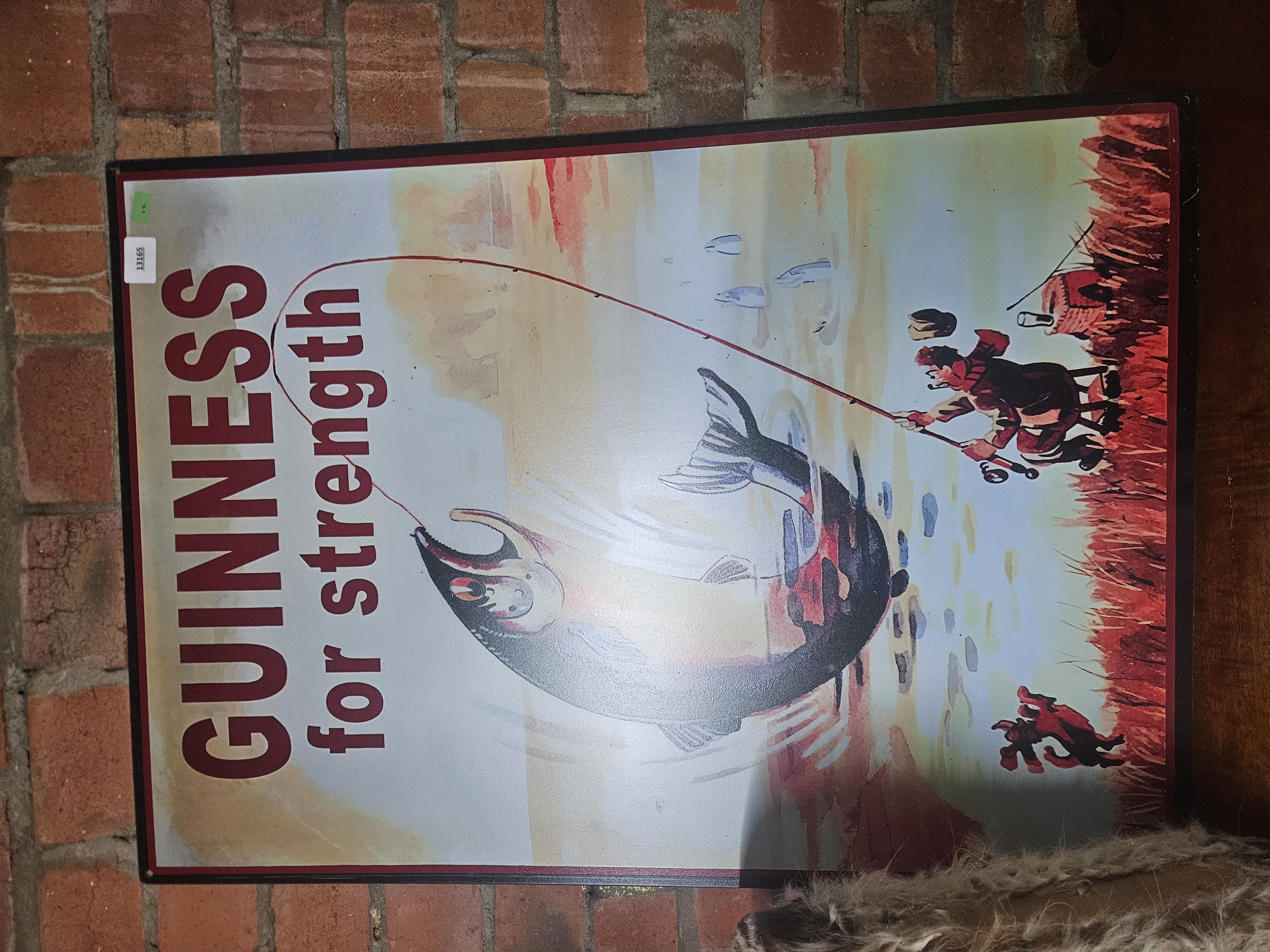 A Reproduction Metal Guinness Advertising Sign Featuring Fisherman and Salmon