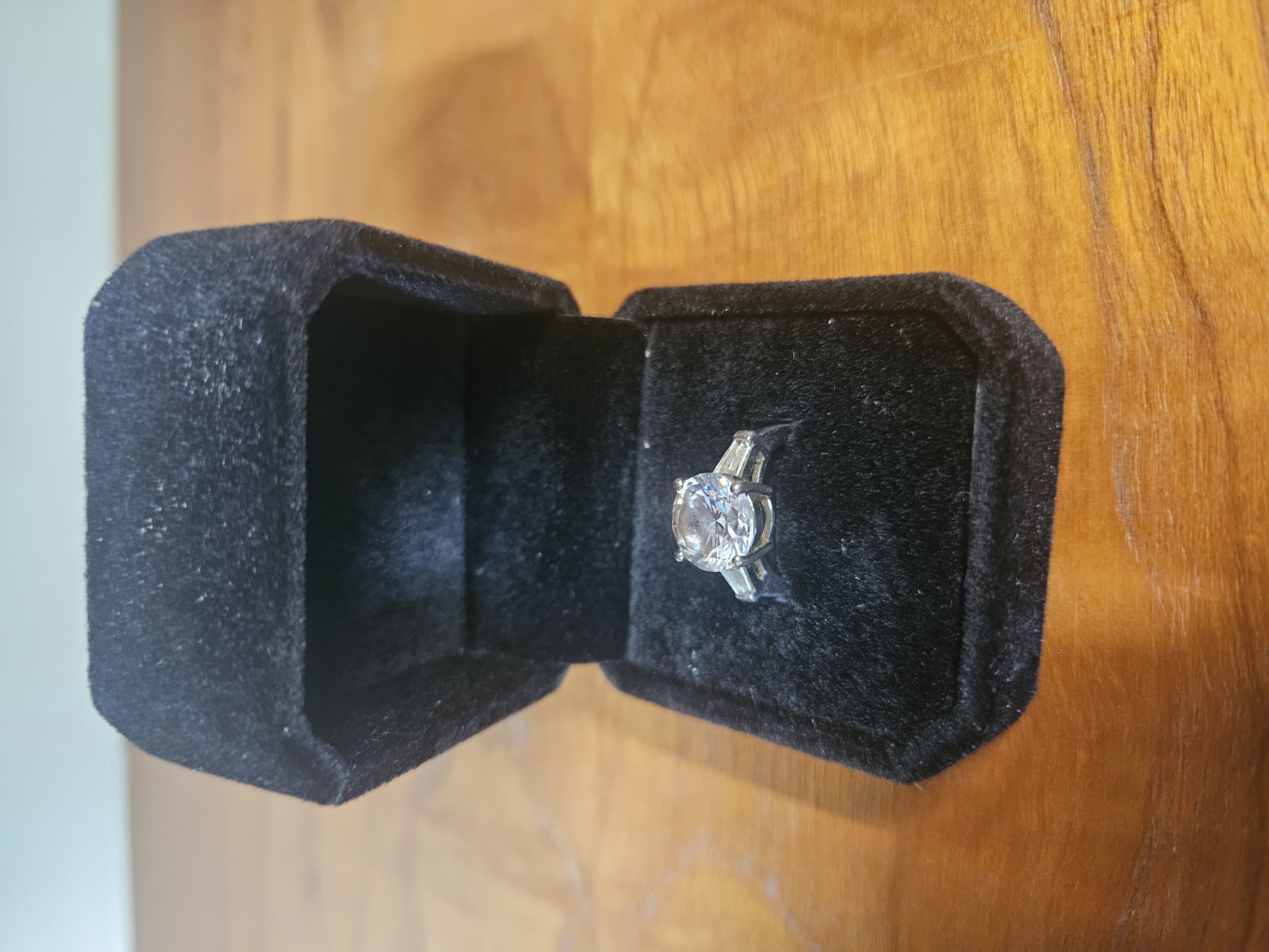 A silver Solitaire Engagement Style Ring with Baguette Cut Shoulder Stones
