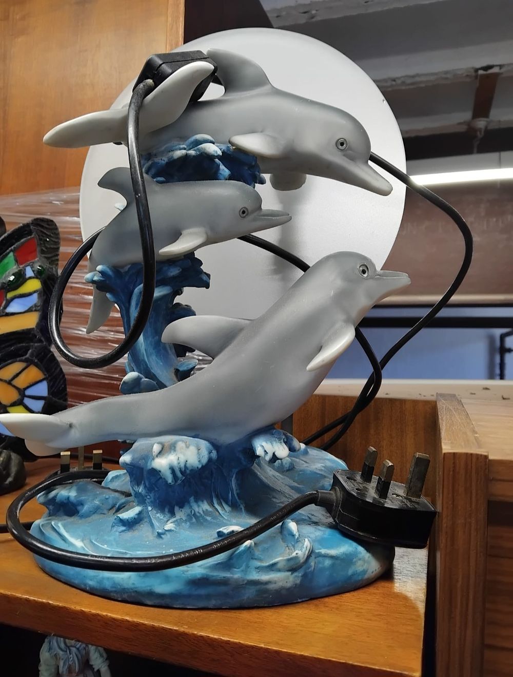 Lot 141 – A Polychrome Resin Table Lamp Depicting a Trio of Dolphins Leaping Through Waves