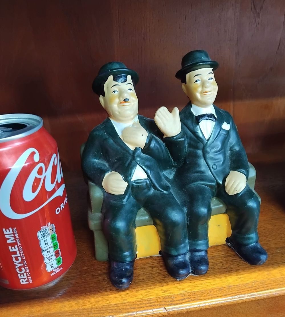 Lot 147 – A Polychrome Painted Figurine Depicting Laurel and Hardy Seated on a Bench