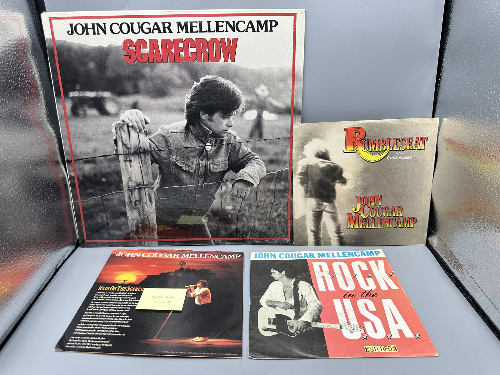 John Cougar Mellencamp: Scarecrow (1985), Club Edition; AND Three (3) 7-inch 45 rpm records with picture sleeves: Rumbleseat; Rain On the Sc