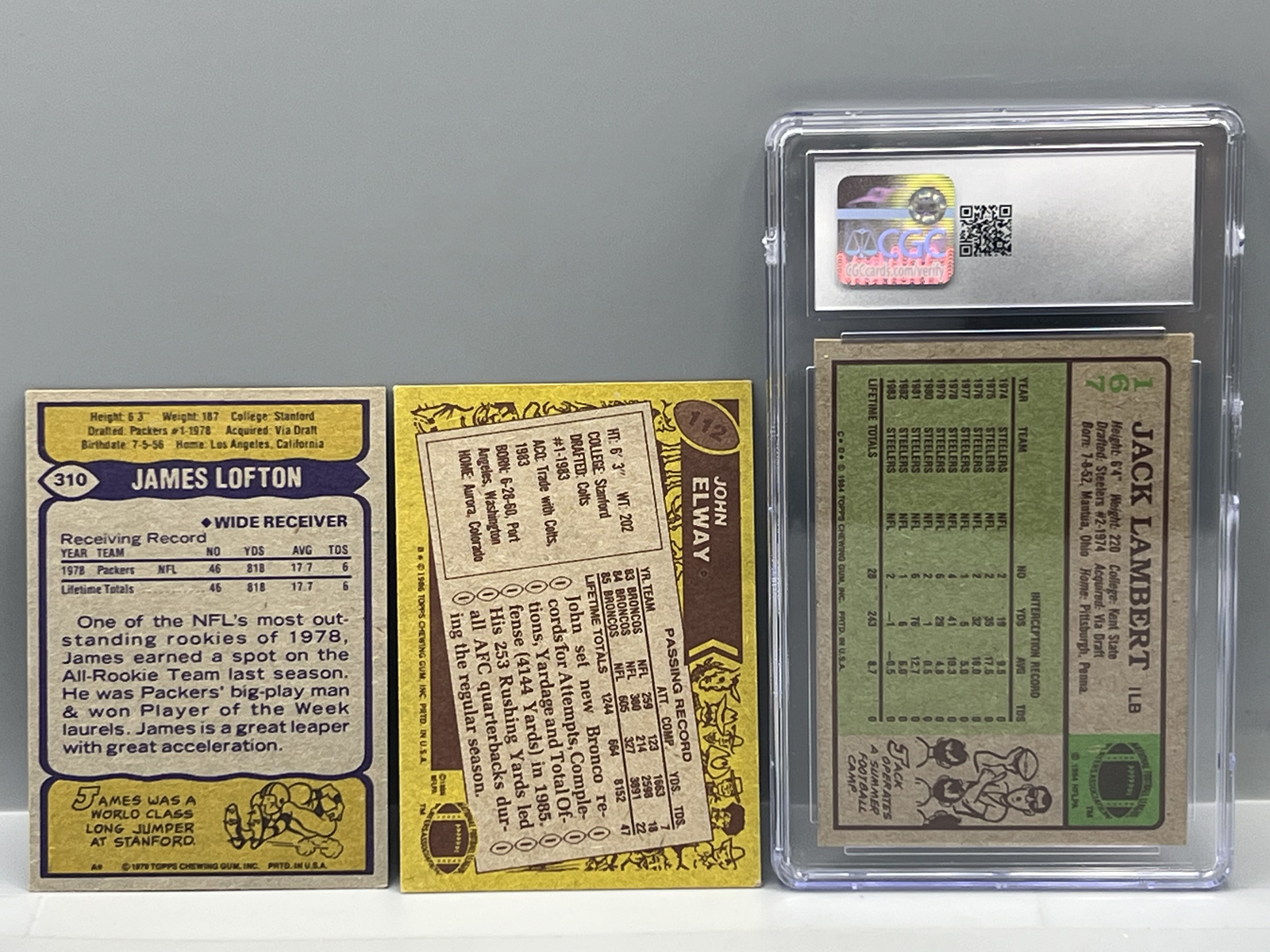 1979 Topps James Lofton RC #310, 1986 Topps John Elway #112, & 1984 Topps Jack Lambert #167 CGC NM+ 7.5