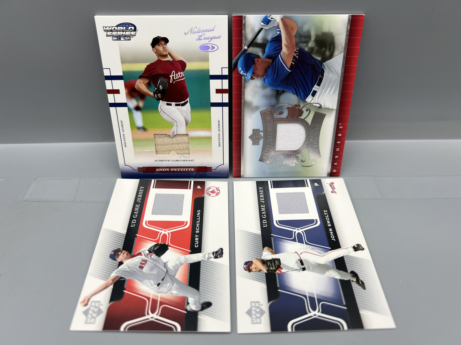 Lot of (4) Baseball Star Player Relic Cards - Andy Pettitte #/100, Mark Teixeira, Curt Schilling, & John Smoltz