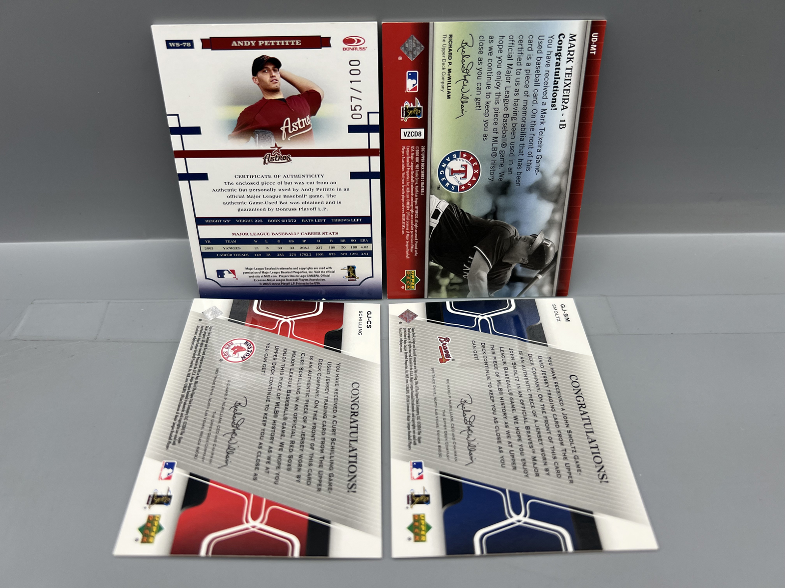 Lot of (4) Baseball Star Player Relic Cards - Andy Pettitte #/100, Mark Teixeira, Curt Schilling, & John Smoltz