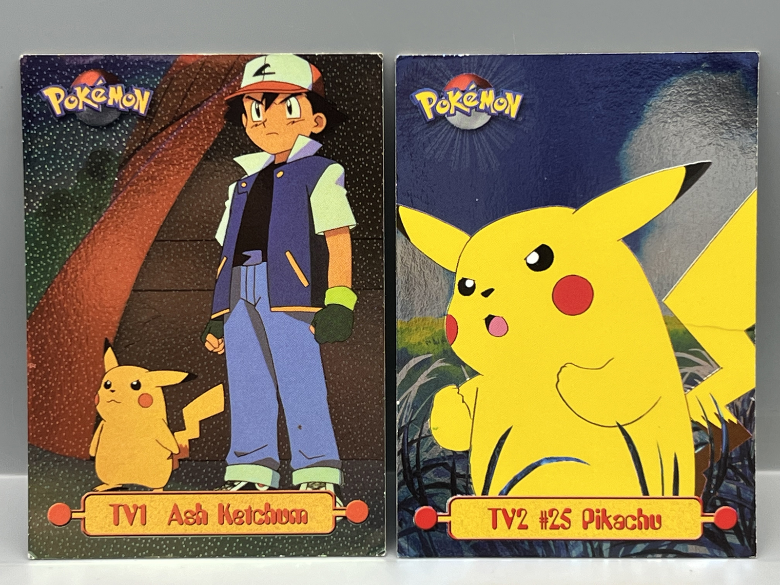 1999 Topps Pokemon TV Ash Ketchum 2nd Print Foil #TV1 & Pikachu 1st Print Foil #TV2