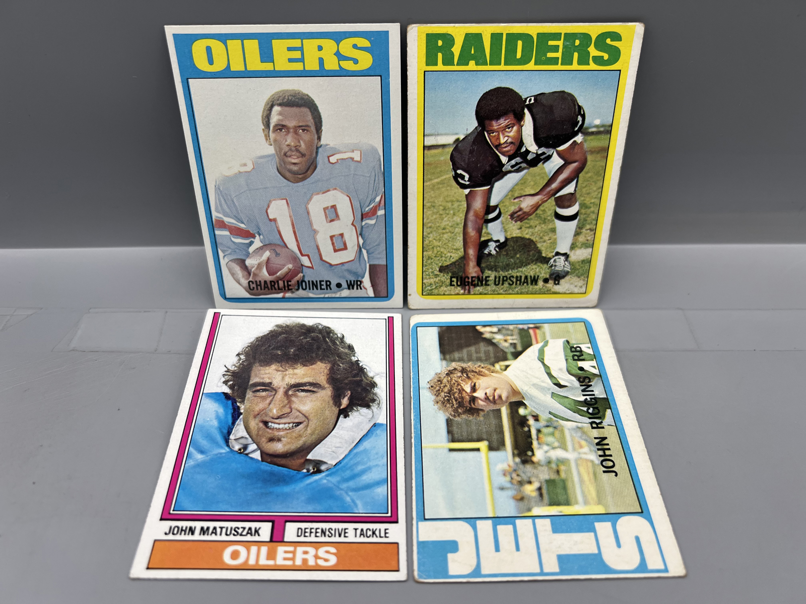 (4) 1970s Topps Football Star Player Rookie Cards - Varying Conditions - Charlie Joiner, Eugene Upshaw, John Matuszak, & John Riggins