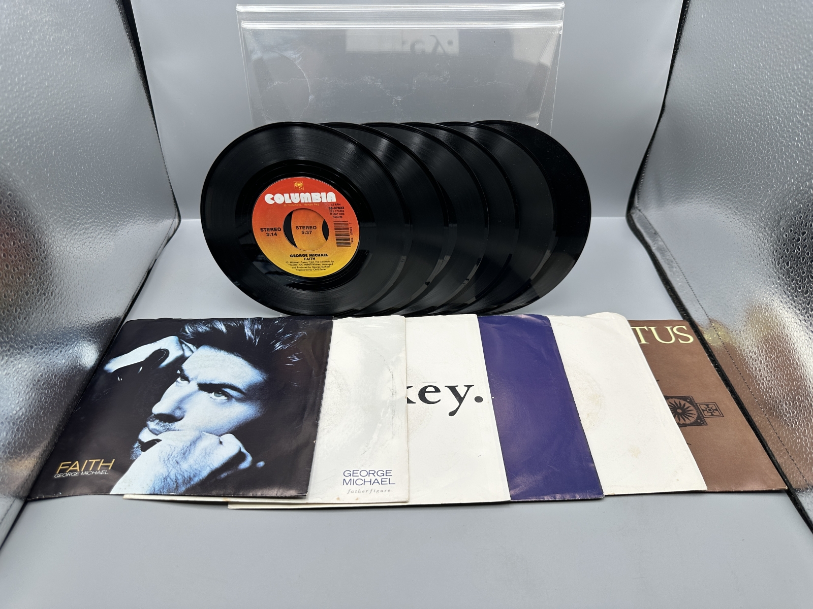 George Michael: Six (6) 7-inch 45 rpm records with picture sleeves: Faith (1987); Father Figure (1987); Monkey (1988); Kissing A Fool (1988)