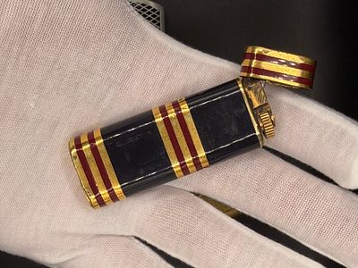 שני מצתים יפייפים. אחד מהם של חברת Cartier היוקרתית עם פסים בגווני כחול-שחור, בורדו וזהב, הדגם 