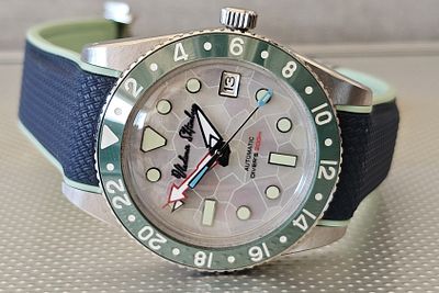 שעון בעבודת יד עם עיצוב ייחודי שהורכב על ידי שען מומחה בצבע כסוף פנינה בלוח עם בזל בצבע ירוק- 