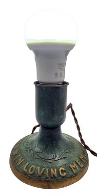 מנורת זכרון ברונזה בפטינה ירוקה ישראליאנה, נושאת את הכיתוב "לזכר עולם", גובה 11 ס"מ