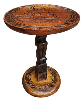 מעמד עץ אפריקאי לעציץ או פסל, מעוטר חריטה ורגל מגולפת, גובה 42 ס"מ, קוטר 30 ס"מ. 
הרהיטים 