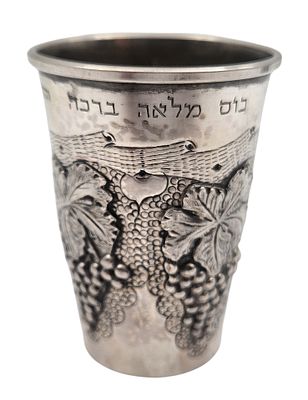 כוס קידוש כסף 925 מעוטרת בתבליטי גפנים ואשכולות ענבים, נושאת חריטת ברכה מהרב ז. חרל"פ, חתומה 
