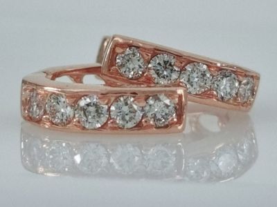 A pair of 14K rose gold horseshoe-shaped hoop earrings studded with natural diamonds weighing 