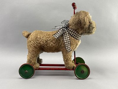 Vintage Plush Dog Pull Toy, 18 Inches. Vintage toy dog pull-along on wheels. Features a 
