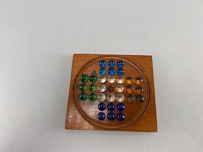 Wooden Solitaire Game w/ Glass Marbles. Vintage wooden solitaire game featuring a circular board 
