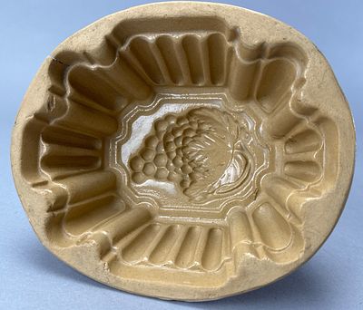 Yellow Ware Grape Mold, 7 Inches. Yellow ware grape mold featuring ribbed sides and an interior 
