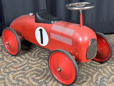 Red Metal Pedal Car. Red metal pedal car featuring a number "1" on both sides and top. It 