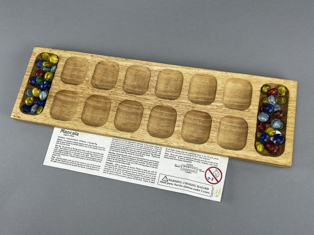 Mancala Board Game & Stones. Mancala board measures 18" x 5.5". 1 Mancala stone is missing and 