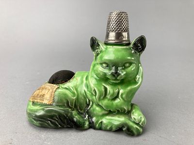 Green Ceramic Cat Pin Cushion with Thimble. Ceramic cat-shaped pin cushion with a thimble on its 