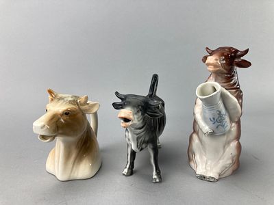 Set of Three Ceramic Cow-Shaped Pitchers. A group of three ceramic cow-shaped pitchers. The set 