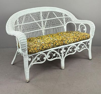 White Wicker Loveseat with Floral Cushion. White wicker loveseat, with a lattice back design 