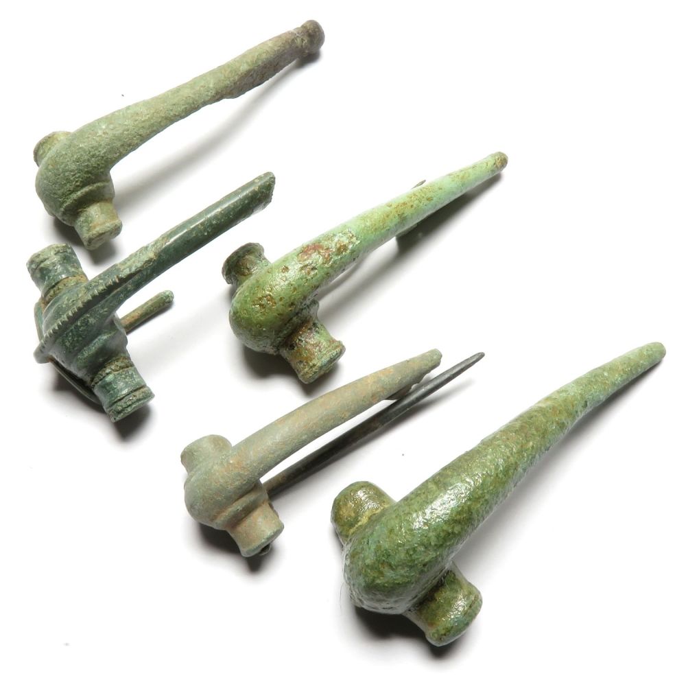 Lot 1034: Roman brooch group. Five Polden hill type brooches,...