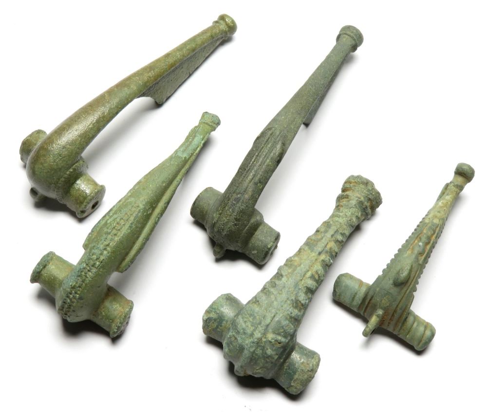 Lot 1038: Roman brooch group. Four Polden hill type brooches...